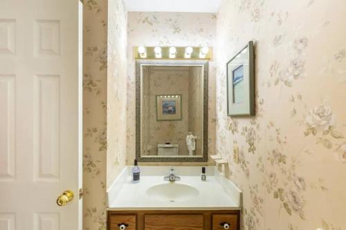 a bathroom with a sink and a mirror at Lrge 5 BR 9 Beds Near DC-Pool, Hot Tub, Gym, Game Rm, Fire Pit in Bowie