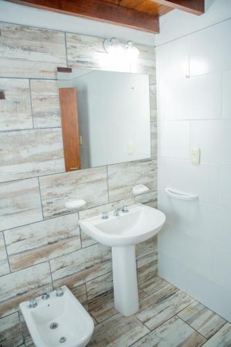 a bathroom with a sink and a toilet at Cabañas Costa Alta in Mina Clavero
