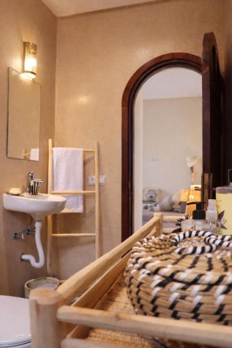 a bedroom with a bed and a sink and a mirror at Villa Dar Nata Marrakech in El Mers