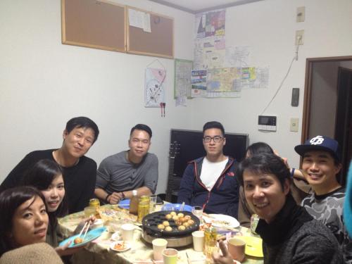 a group of people sitting around a table eating at Guest House Wa N Wa in Osaka