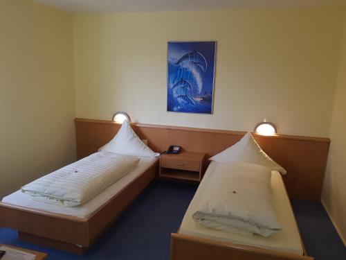 Hotel Stadt Baunatal في باوناتال: غرفة فندقية بسريرين واضاءتين