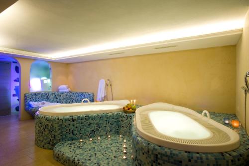 a large bathroom with a tub and two seats at Hotel La Villa in La Villa