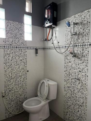 a bathroom with a toilet and a shower at Villa Ostara Kota Batu in Batu