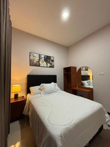 a bedroom with a large white bed and a mirror at Villa Ostara Kota Batu in Batu