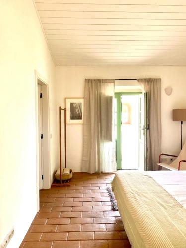a bedroom with a bed and a room with a window at Casas do Seixo - Monsaraz in Cabeça de Carneiro