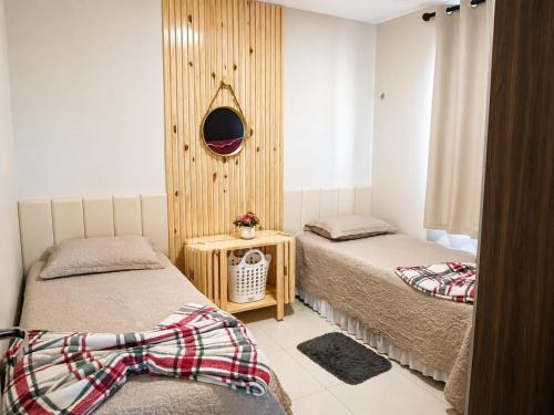 a bedroom with two beds and a mirror on the wall at dreams of the mountains in Bananeiras