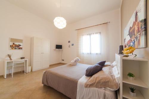 a white bedroom with a bed and a desk at Bianco Sale Trapani in Rilievo