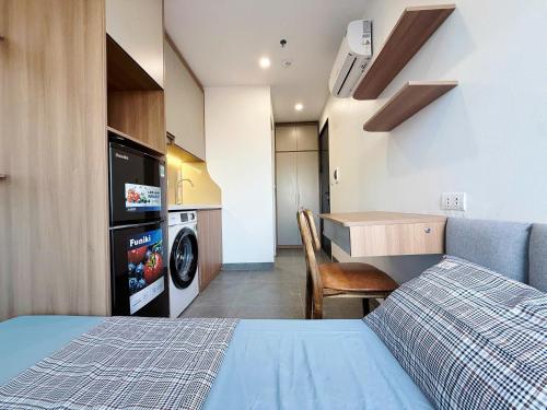 a bedroom with a bed and a kitchen with a washing machine at Gang Thep Hotel in Thái Nguyên