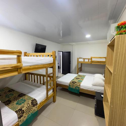 a room with three bunk beds in it at Hotel Habitaciones D y Mar in Tolú