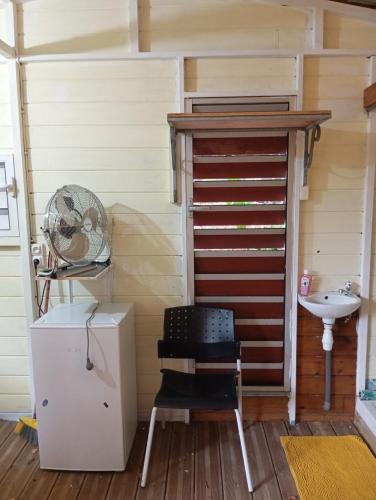 a small room with a chair and a sink at cabane dans le jardin in Morne-à-lʼEau