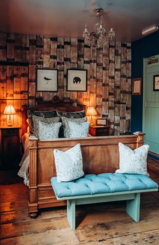 a bench with pillows on it in a room at The Roebuck Inn in Mobberley