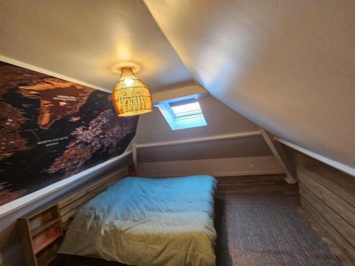 a small attic room with a bed and a light at Le Forest Lodge 325 in Béthune