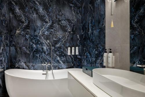 a bathroom with a bath tub and a sink at The Encore Hotel Nakuru in Nakuru
