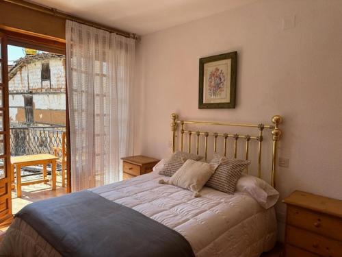 a bedroom with a bed and a balcony at Casa Lobo in Ucero