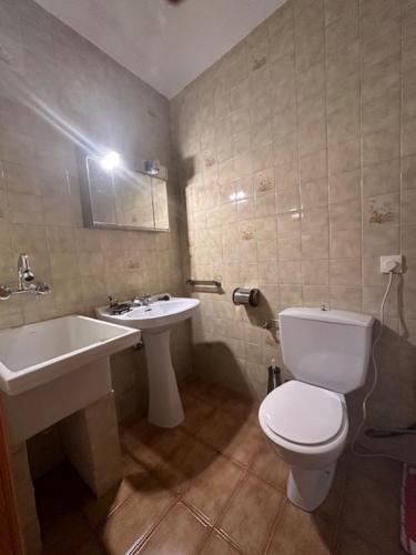 a bathroom with a white toilet and a sink at Casa Lobo in Ucero