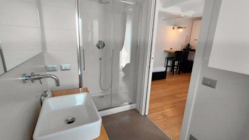 a white bathroom with a shower and a sink at Casa Lame in Bologna