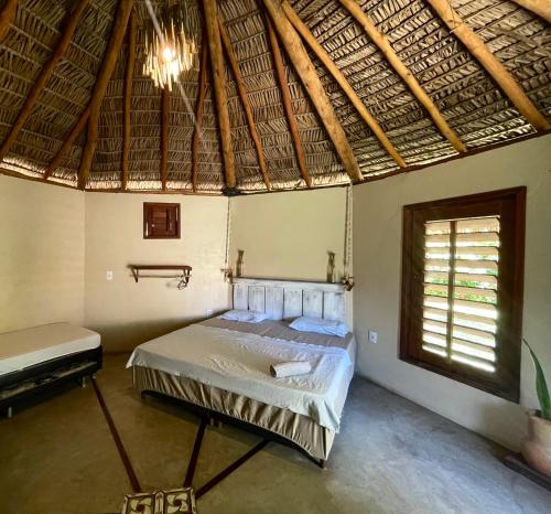 a bedroom with a bed in a room with a window at Vila Prana in Barra Grande