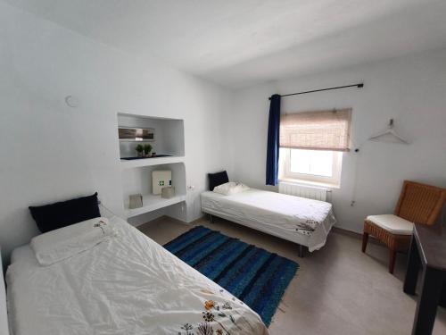a bedroom with a bed and a desk and a window at Casa Limón - Alpujarras in Órgiva