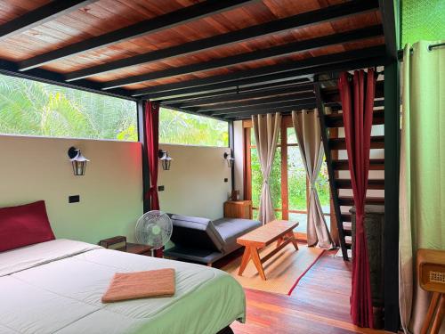 a bedroom with a bed and a chair in a room at Tee Bungalow in the jungle in Ao Nang 