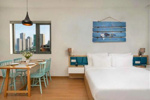 a bedroom with a bed and a table and a dining room at Dolphin Hotel and Apartment in Danang