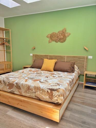 a bedroom with a large bed with a wooden headboard at Amelia Apartment in Maniago