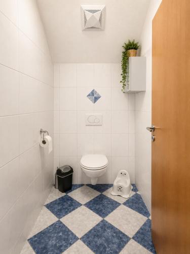 a bathroom with a toilet and a checkered floor at Ferienwohnung Biohof Untermar in Obervellach