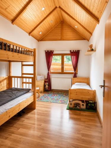 a bedroom with two bunk beds and a wooden ceiling at Ferienwohnung Biohof Untermar in Obervellach