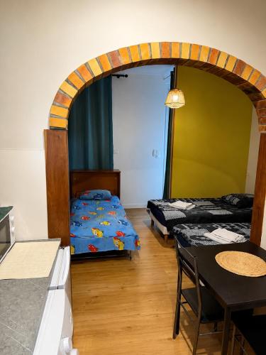 a room with two beds and a table and a dining room at Studio Magnifique in Darnétal