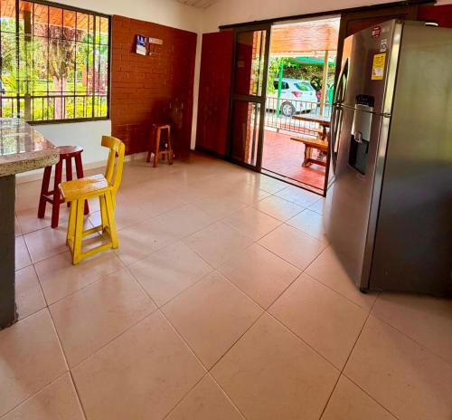 a kitchen with a refrigerator and a table and chairs at Chalet Natalia Montenegro Quindío in Montenegro