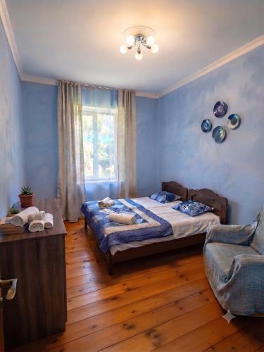 a bedroom with a bed and a chair and a window at Guest House Nino in Mestia