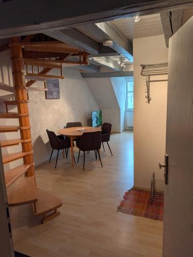 a room with a table and chairs and a staircase at Ferienwohnung Am Markt in Eisfeld