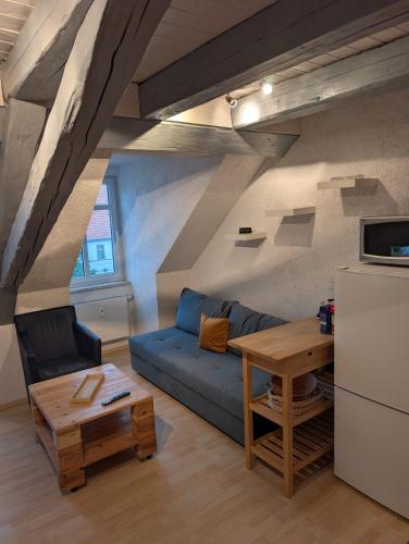 a living room with a blue couch and a table at Ferienwohnung Am Markt in Eisfeld