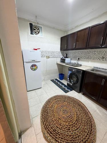 a kitchen with a refrigerator and a washer and dryer at Bedroom Jimi in Al Ain