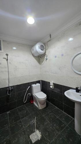 a bathroom with a shower and a toilet and a sink at Bedroom Jimi in Al Ain