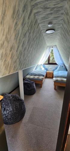 a bedroom with two beds in a room with a ceiling at A-Frame am Ochsenkopf in Mehlmeisel
