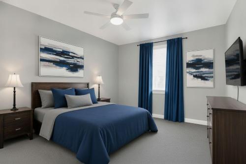a bedroom with a blue bed and a ceiling fan at PEAK AND PINE GETAWAY in Eden