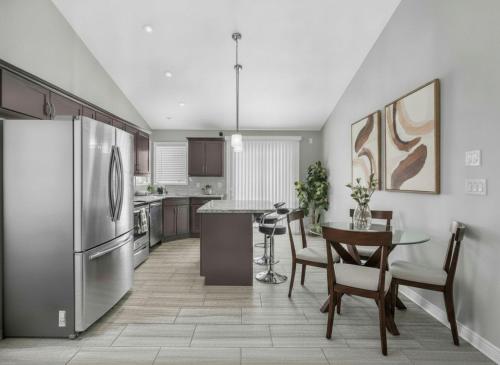 a kitchen with a stainless steel refrigerator and a table at PEAK AND PINE GETAWAY in Eden