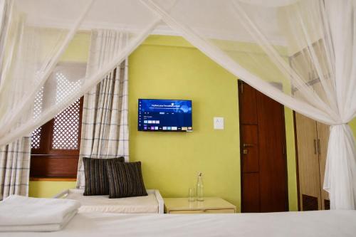 a bedroom with two beds and a tv on the wall at Du Nepal Inn in Kathmandu