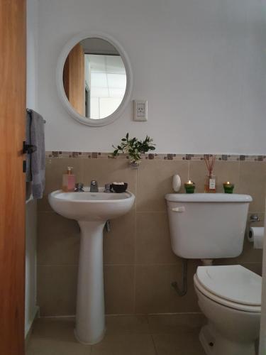 a bathroom with a toilet and a sink and a mirror at La Constancia in Parana