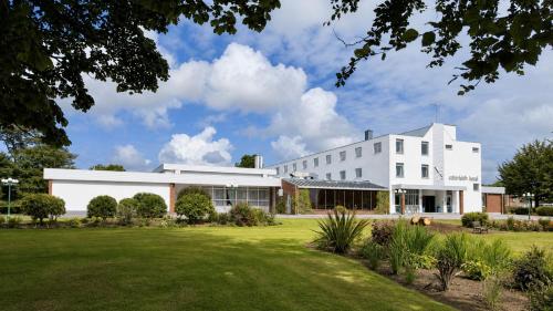 a white building with a lawn in front of it at Cabarfeidh Hotel in Stornoway