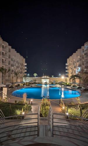 a large pool with blue water at night at منتجع البرنسيسة ريزورت الغردقه in Hurghada