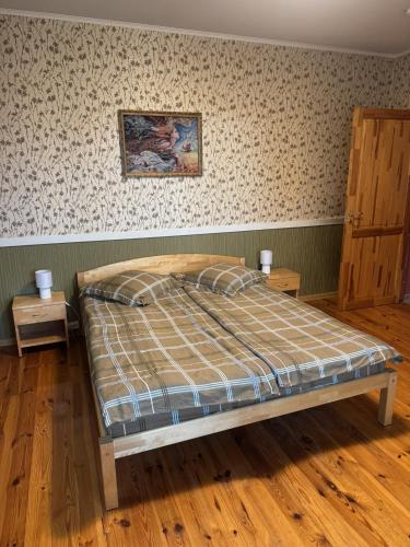a bedroom with a bed and two night stands at Leču muiža in Lēči