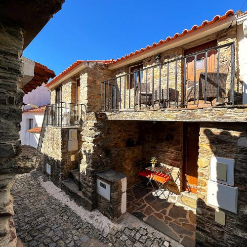 a stone building with a balcony and a stove at Casas dos Carregais in Carregais