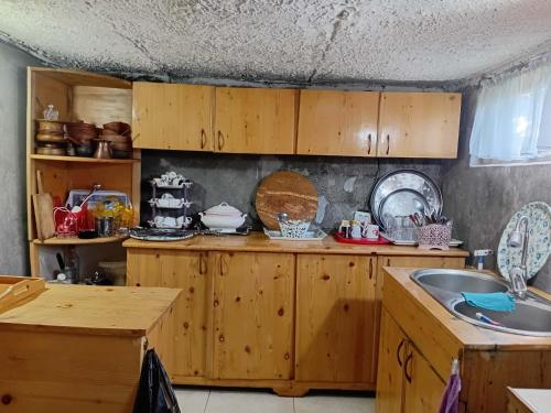 a kitchen with wooden cabinets and a sink at BBR House in Chʼkhakoura