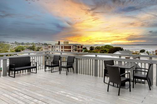 a balcony with chairs and tables and a sunset at Lofts Orizon in Rimouski