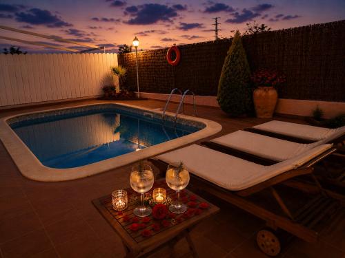 a swimming pool with wine glasses and a tub at Mas Japimon in Creixell