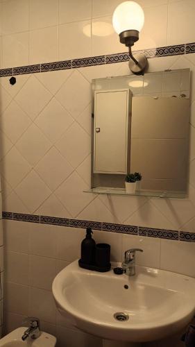 a bathroom with a sink with a mirror and a light at Casa María in Mojácar