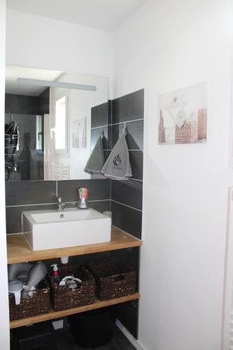 a bathroom with a white sink and a mirror at O Ptit home in Saint-Vincent-sur-Jard
