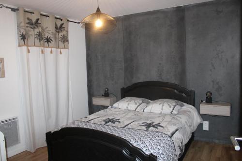 a bedroom with a bed with a gray wall at O Ptit home in Saint-Vincent-sur-Jard