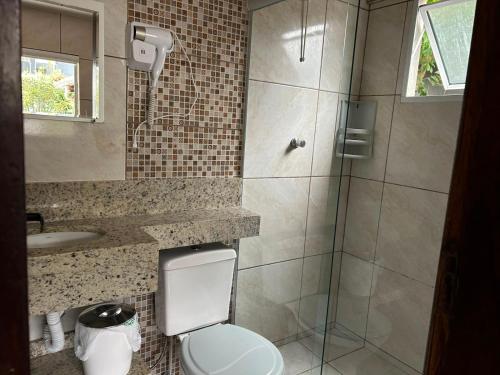 a bathroom with a shower and a toilet and a sink at Aluguel casa Bombinhas in Bombinhas